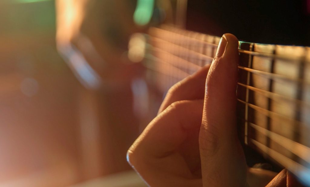 picture of a hand strumming a guitar