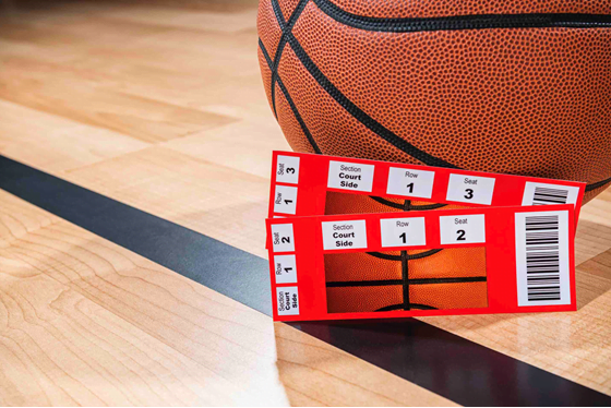 Picture of basketball on basketball court with two tickets.