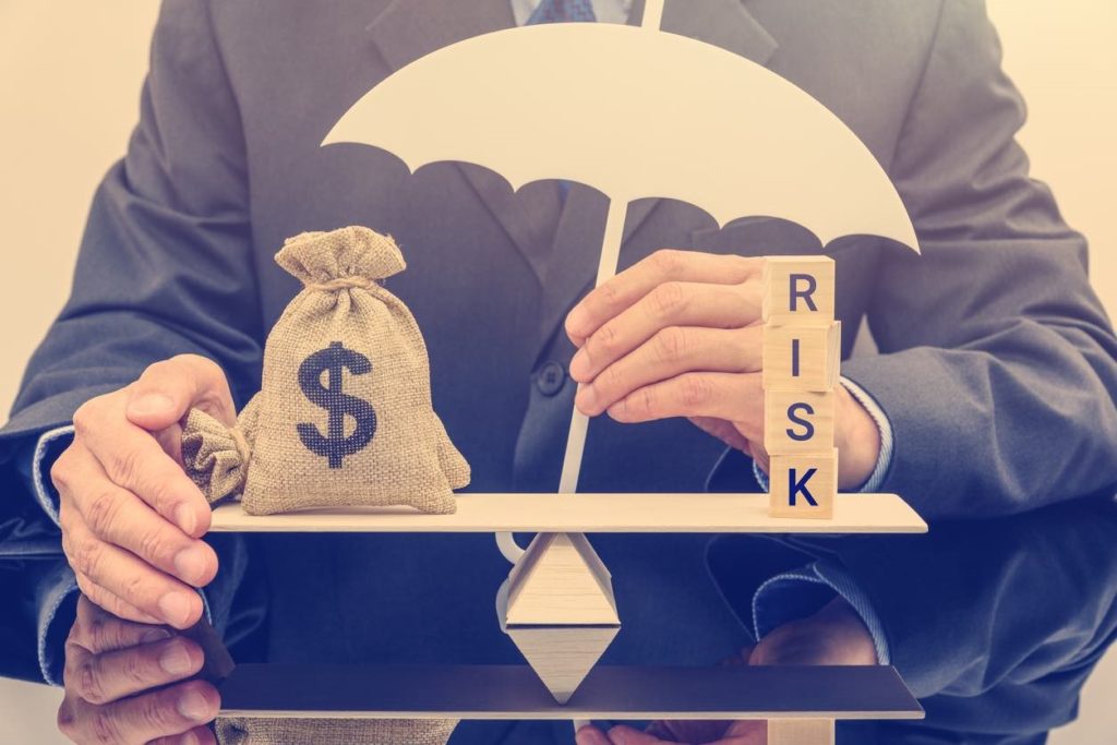 Image illustrating balance with risk on one side and a bag with a money sign on the other.