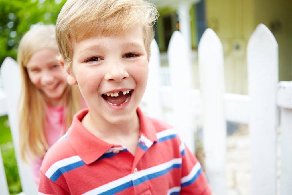 Picture of smiling young boy with missing front tooth.