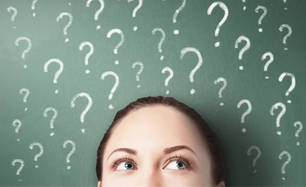 Young professional trying to figure out her why as they lay against a green background with white question marks.