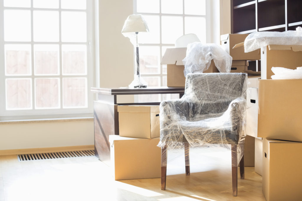 Image of a living room with moving boxes to illustrate downsizing