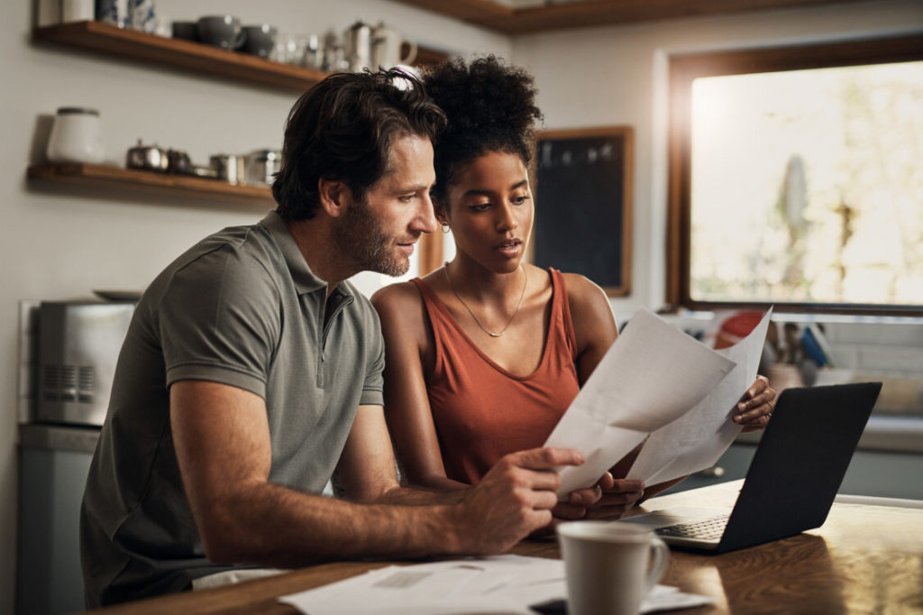 couple sitting at kitchen table reviewing paperwork