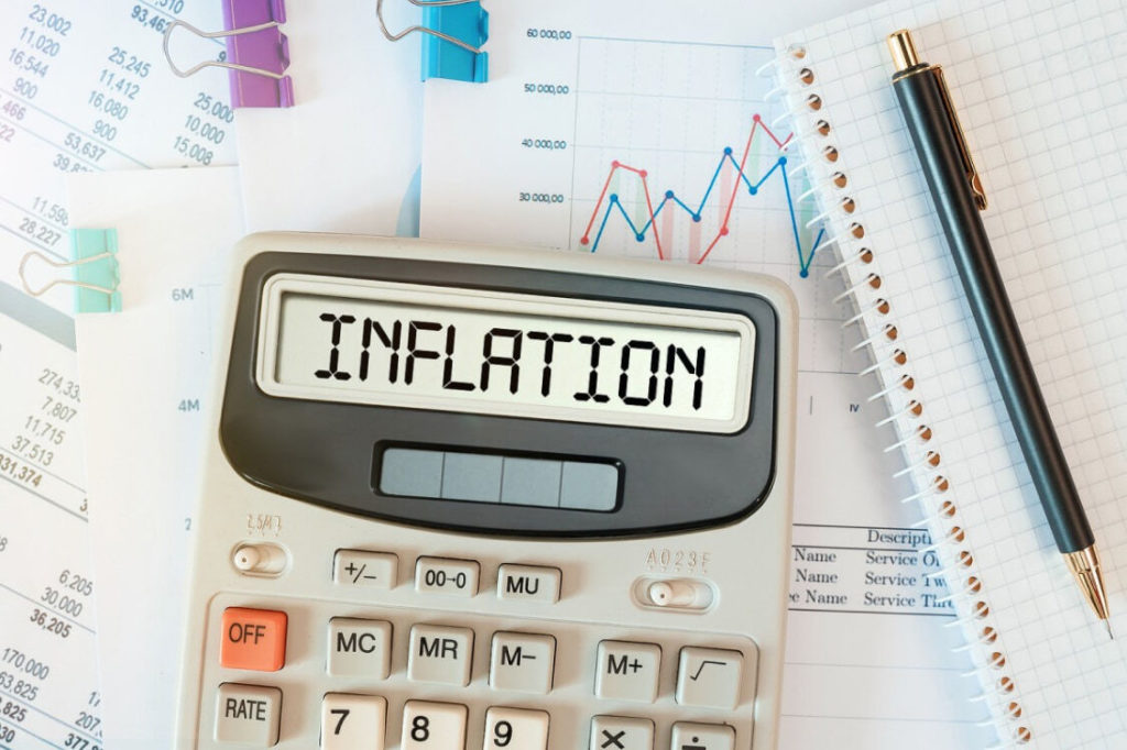 The word inflation on a calculator, which is resting on financial paperwork