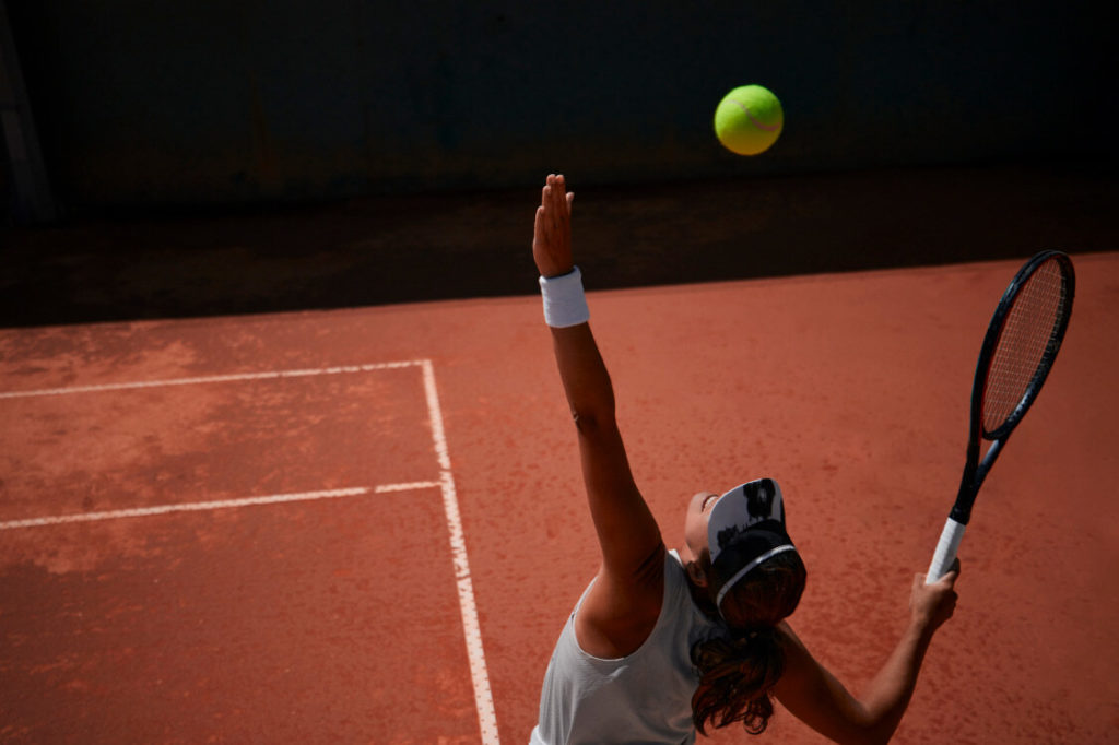 a tennis player serving on a clay court