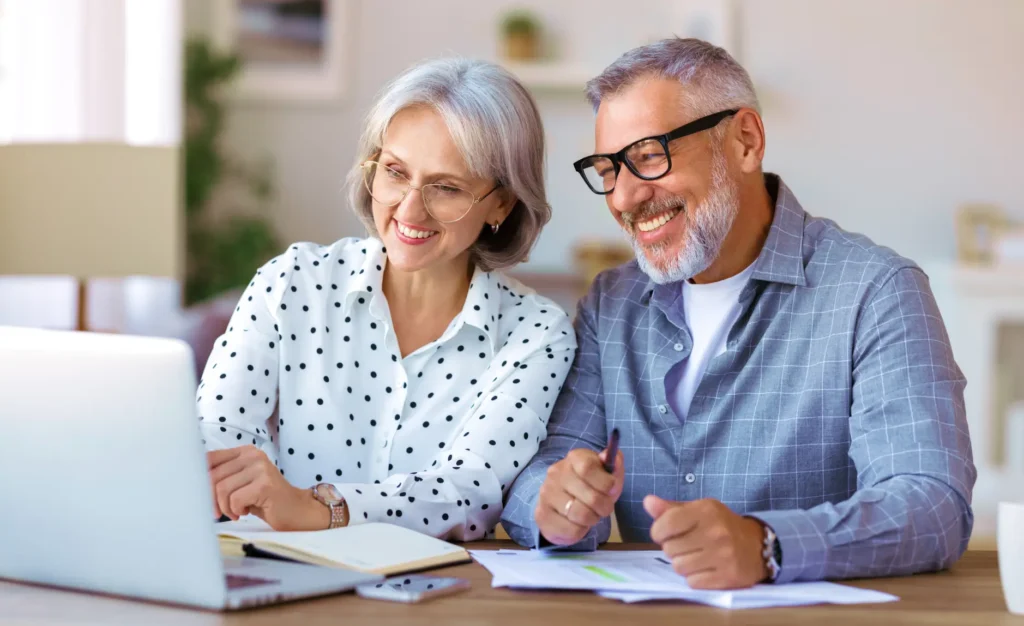 An older couple reviewing their tax plan at a table on a Zoom meeting.