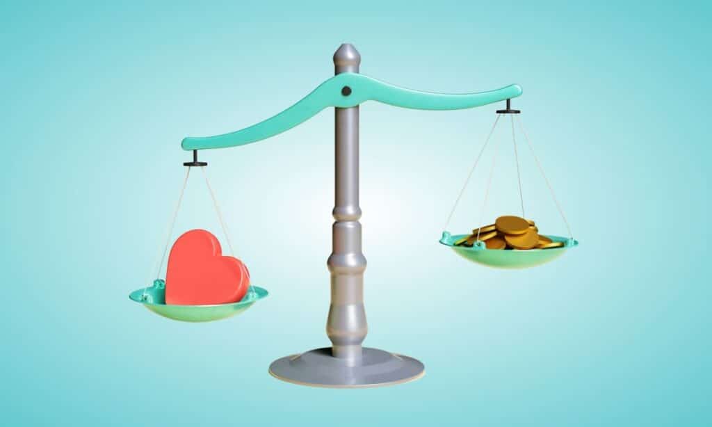 a scale balancing a heart and money. the heart side weighs more.