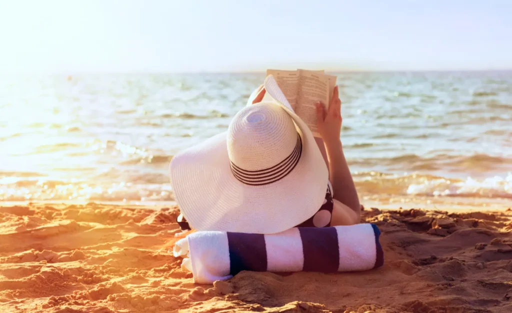 woman relaxing by beach reading