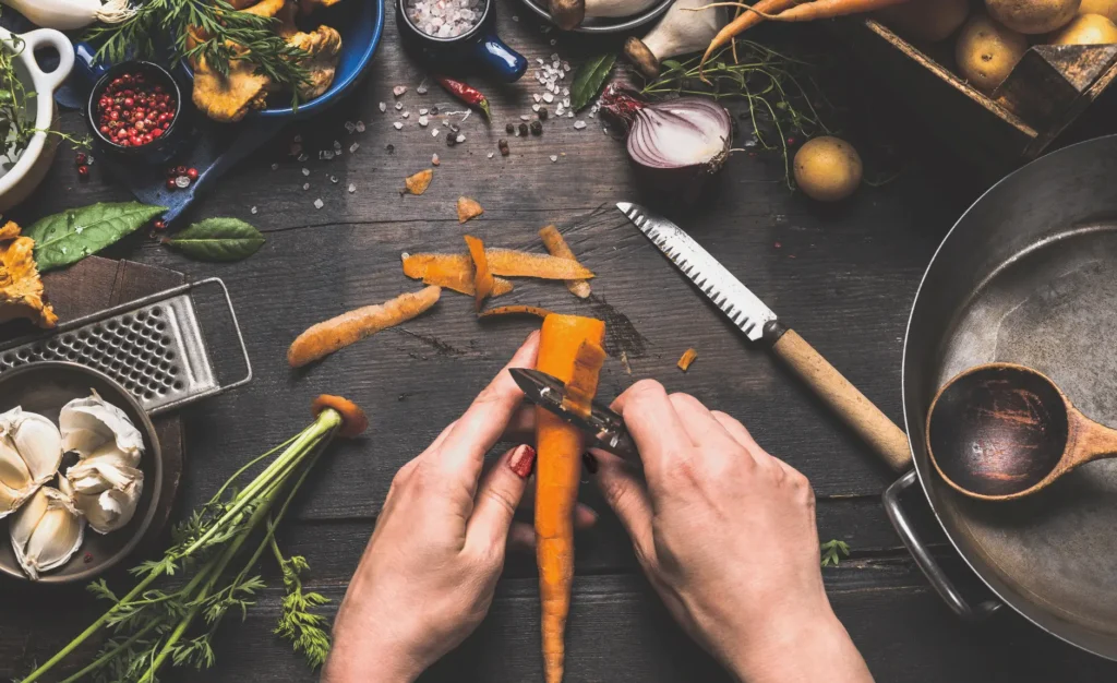 an image of a woman hands as she's peeling a carrot as part of the meal prep process