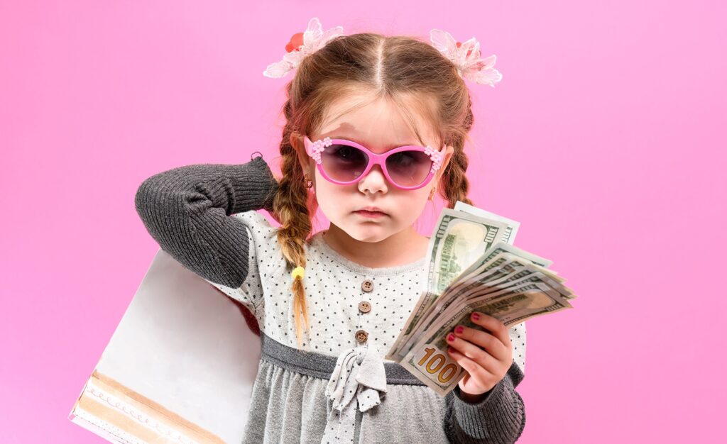 little girl holding 100 dollar bills and a shopping bag