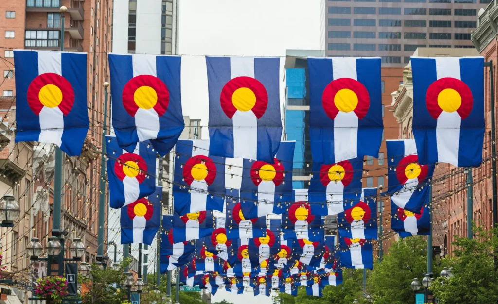 A photograph of mini Colorado state flags and lights lining the street of Larimer Square.