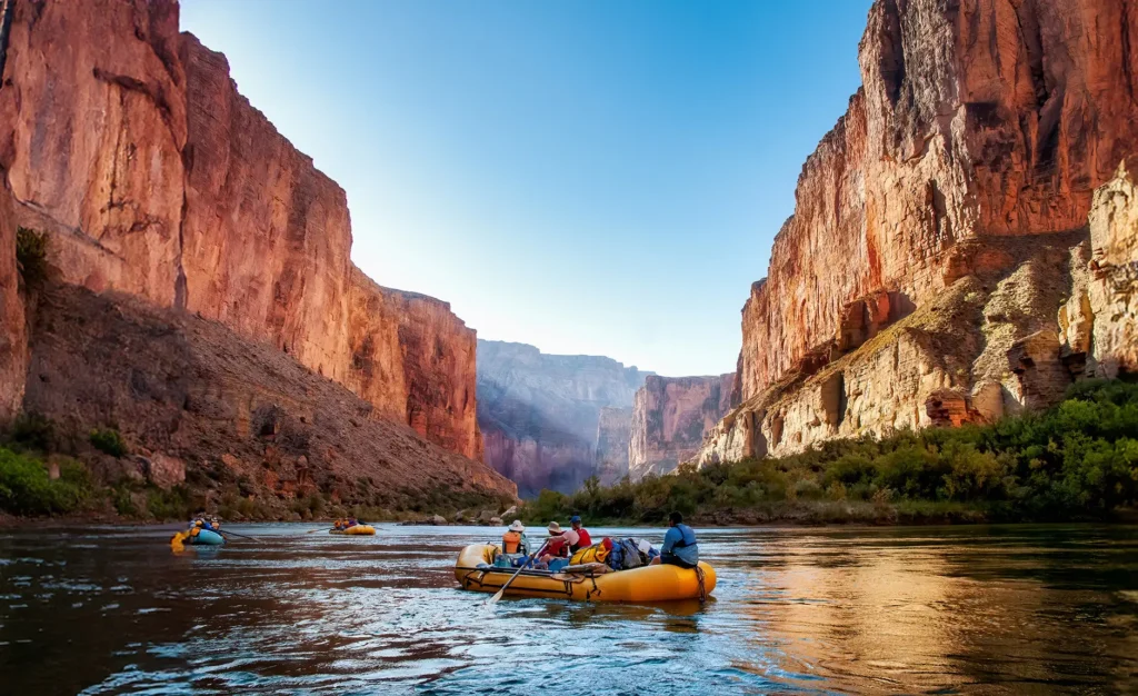 Three rafts on the Colorado River in the Grand Canyon at sunrise