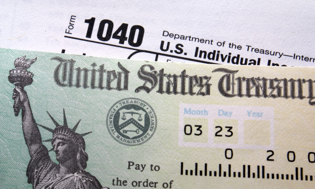 A check from the United States Treasury laying on top of a U.S. 1040 tax form