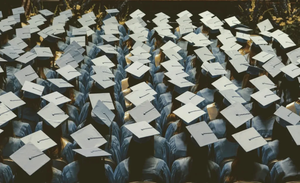 a graduation scene where all you can see is the caps as the graduates watch the ceremony.