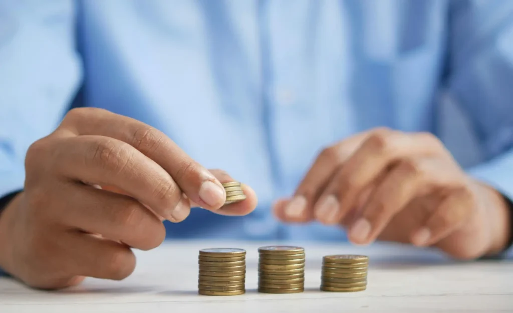 a person at a table dividing change into three piles