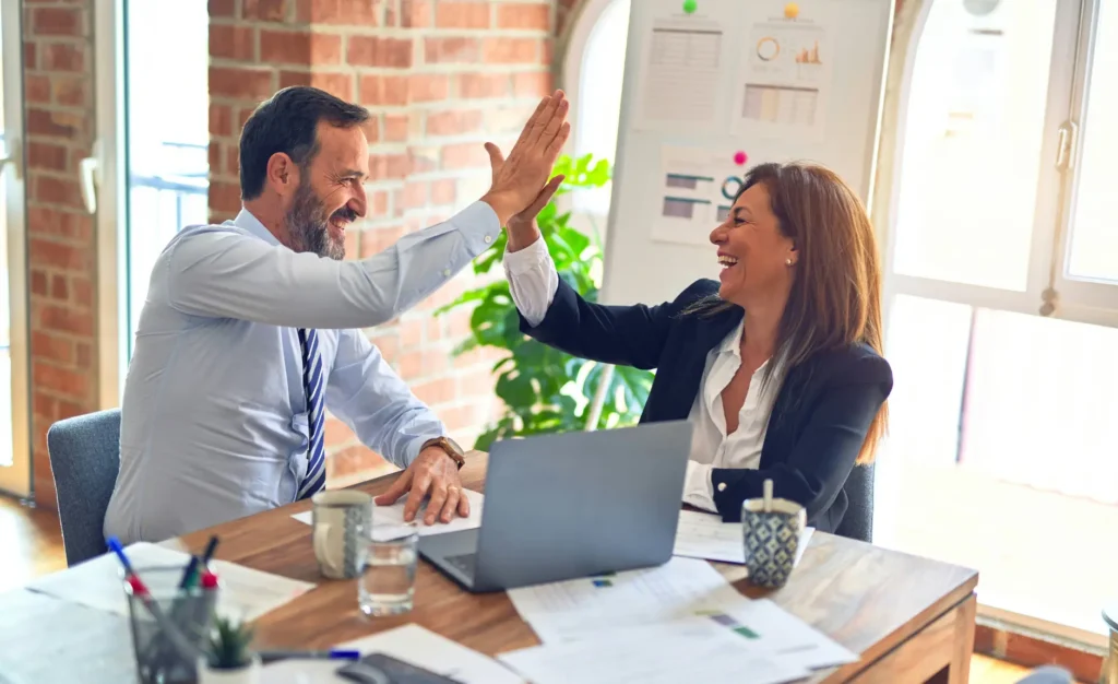 two people high fiving during a portfolio review meeting