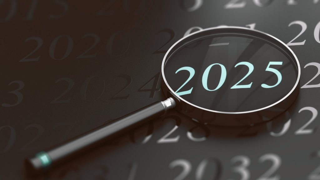 Magnifying glass highlighting the year 2025 on a dark calendar background, symbolizing reflection and looking ahead.