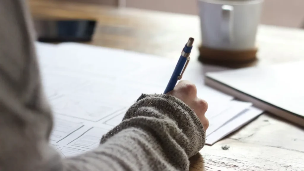 Picture of a woman's hand filling out paperwork.